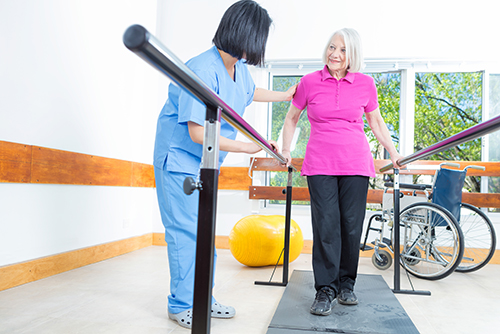 Rehab aid assisting patient with physical therapy